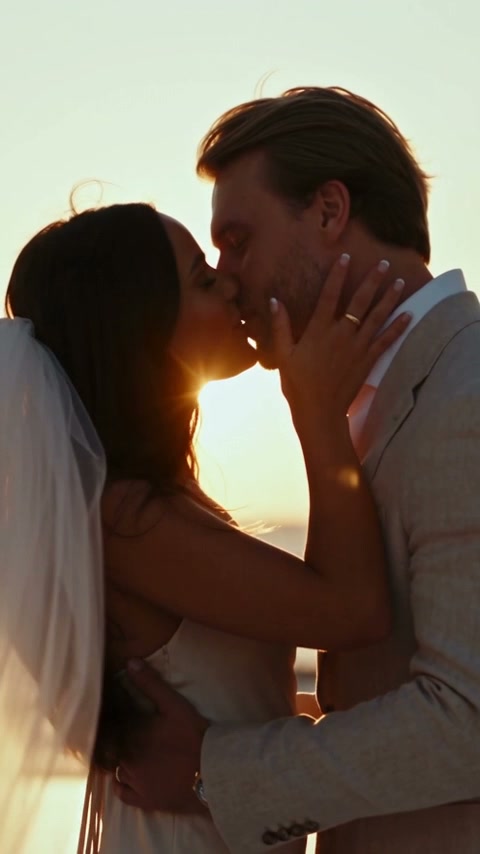 The couple kissing at sunset
